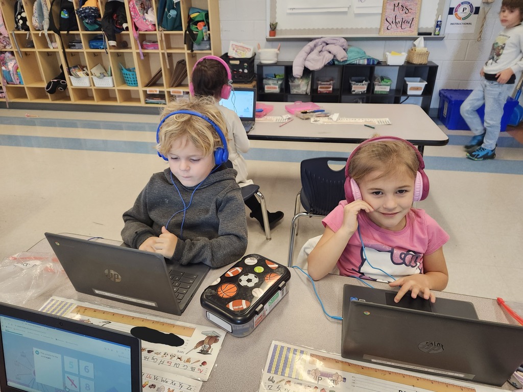 Kindergarten students sitting at their tables working on their Freckle math program
