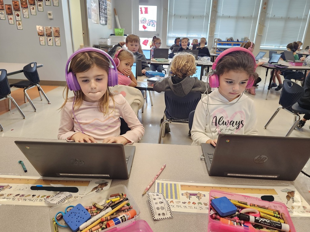 Kindergarten students sitting at their tables working on their Freckle math program