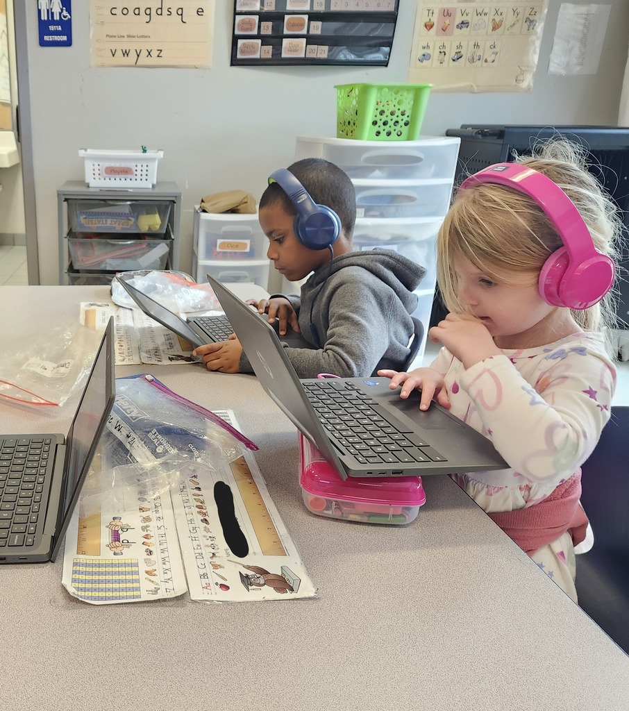 Kindergarten students sitting at their tables working on their Freckle math program