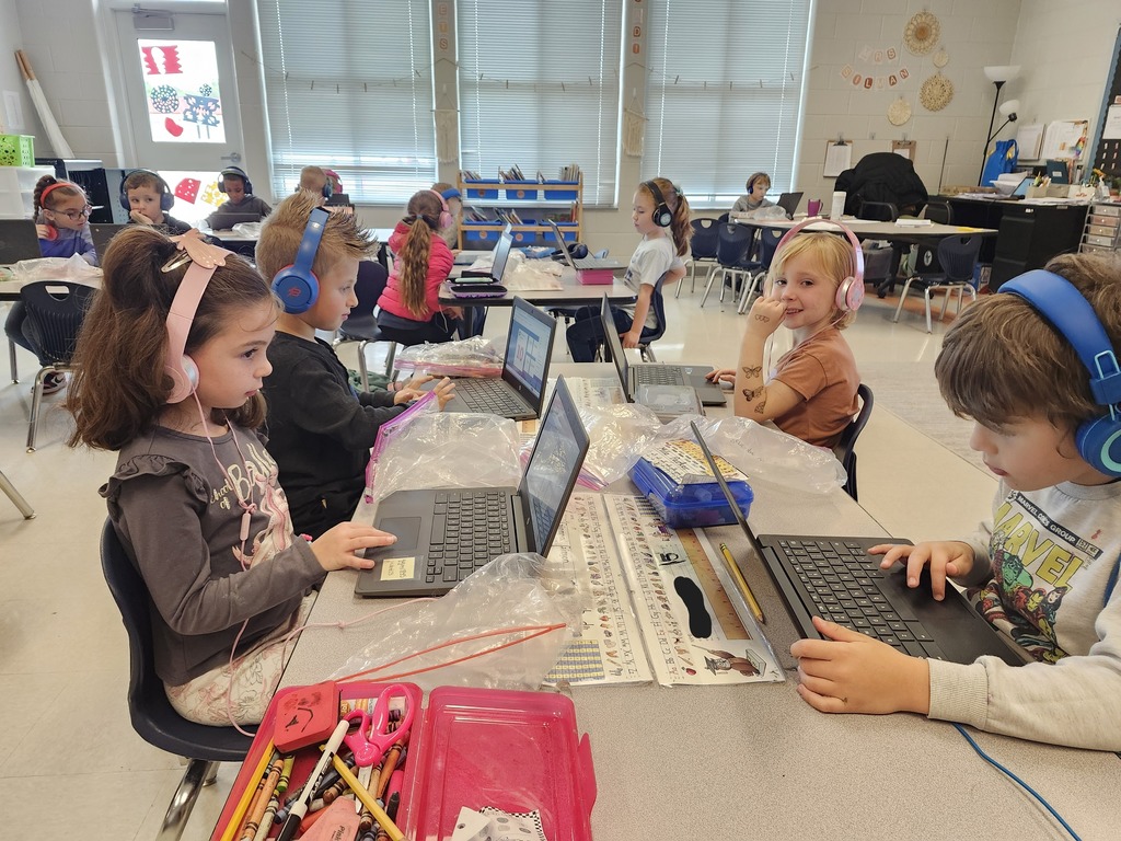 Kindergarten students sitting at their tables working on their Freckle math program