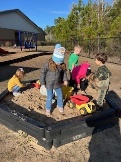 PreK students playing in a sandbox