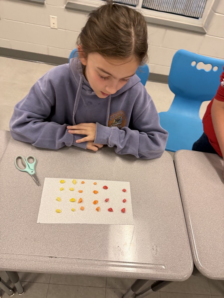 students working with unwrapped starbusts at their desk