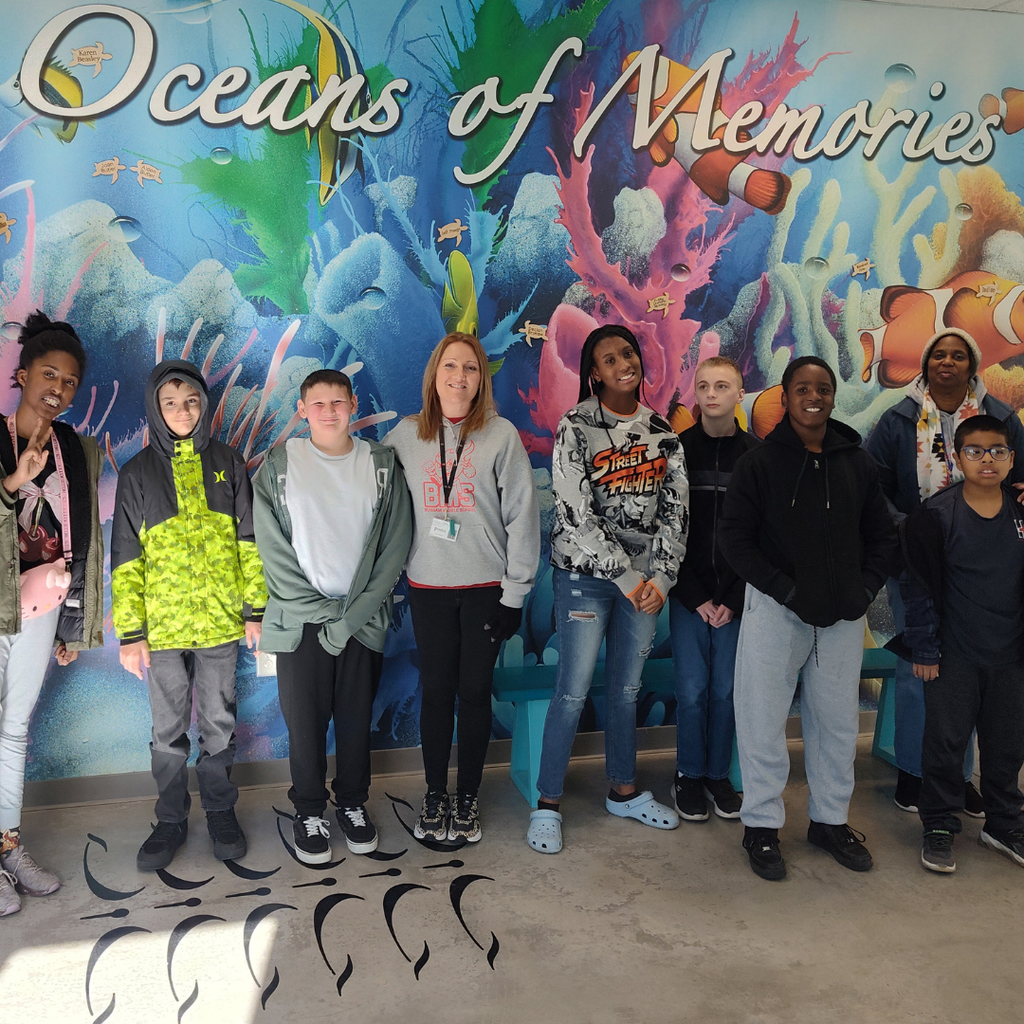 students and teachers standing in front of ocean mural