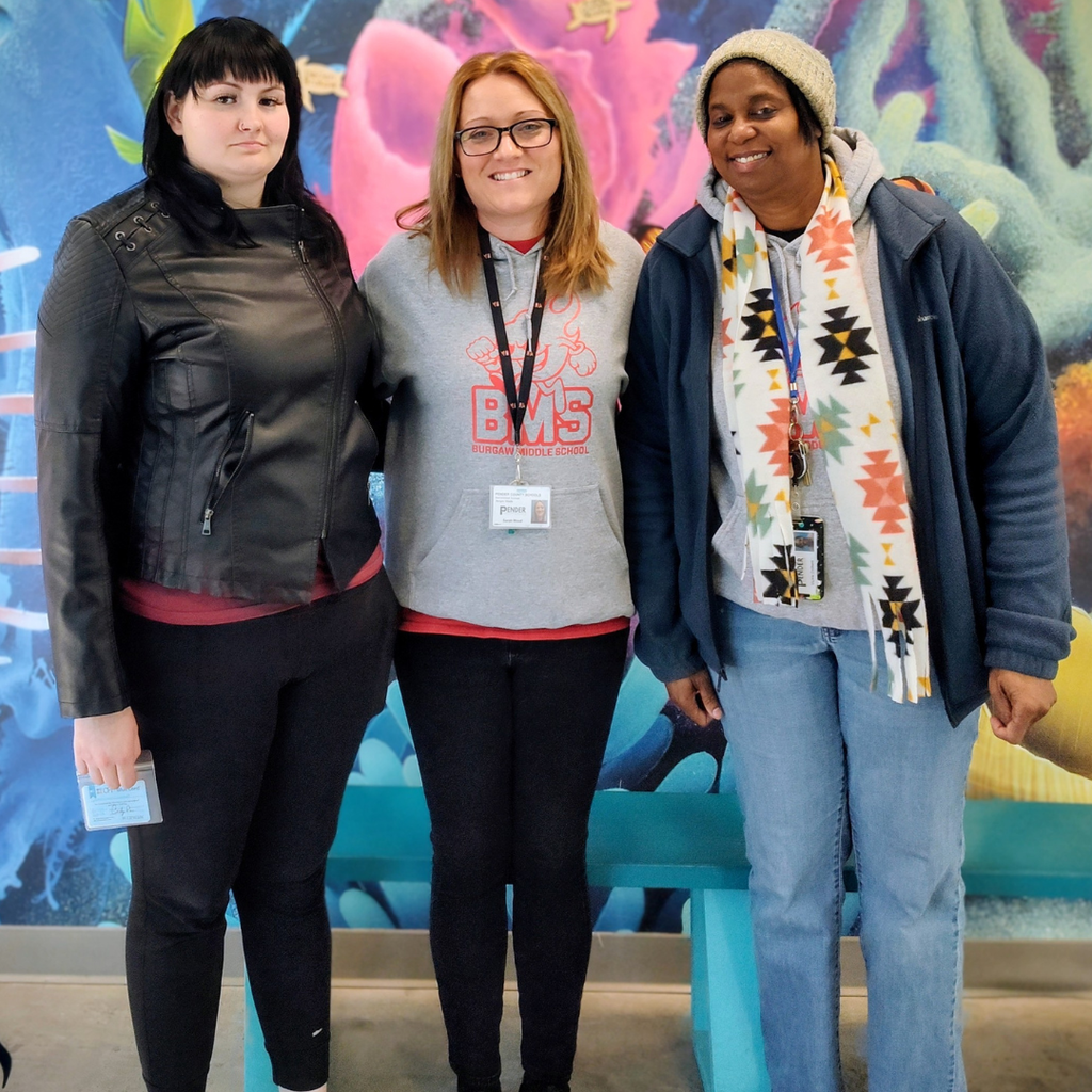 teachers posing in front of mural