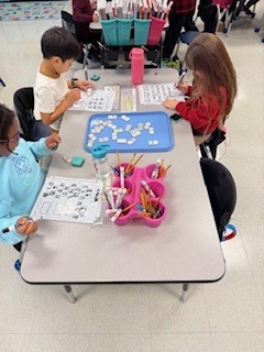 first graders working on math activity at their table