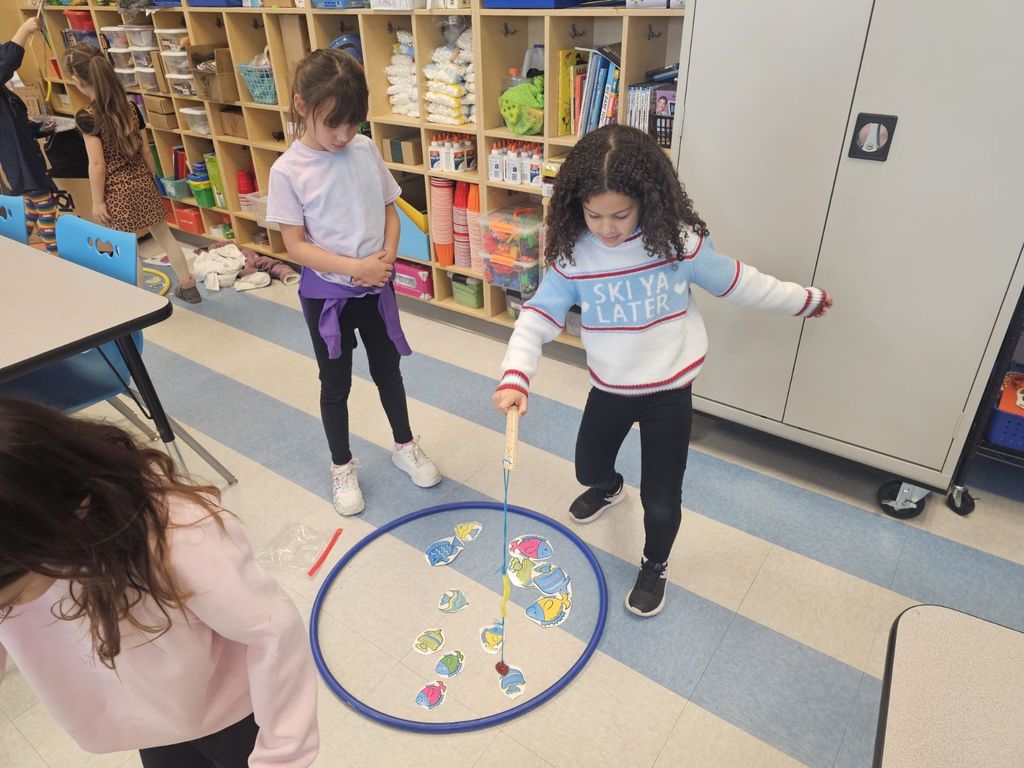 students in STEAM class using a fishing pole with a magnet to collect fish