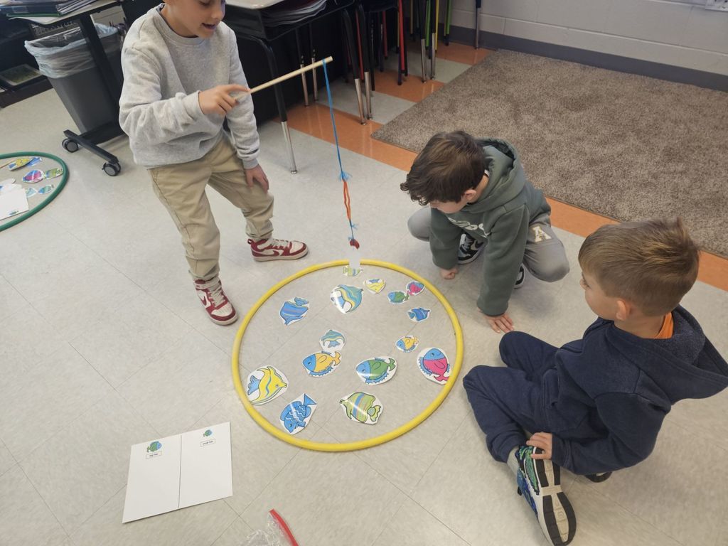 students in STEAM class using a fishing pole with a magnet to collect fish