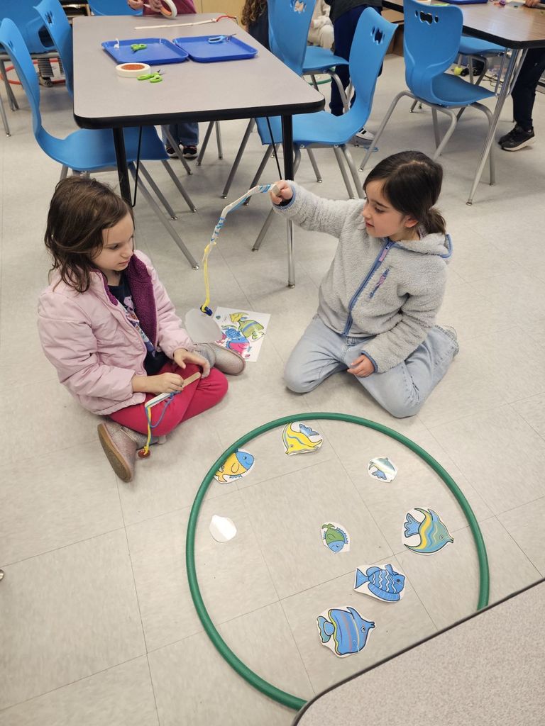 students in STEAM class using a fishing pole with a magnet to collect fish