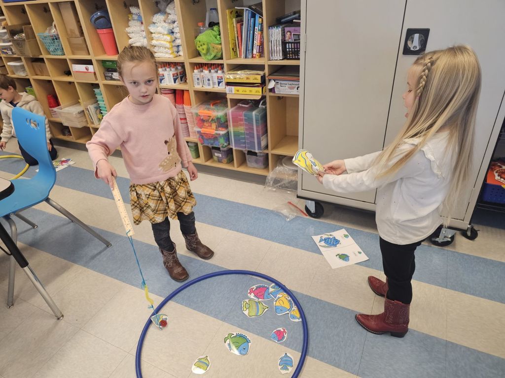 students in STEAM class using a fishing pole with a magnet to collect fish