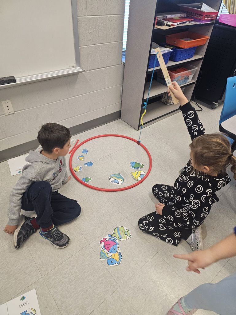 students in STEAM class using a fishing pole with a magnet to collect fish