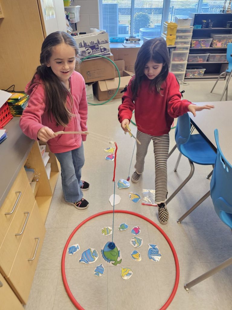 students in STEAM class using a fishing pole with a magnet to collect fish
