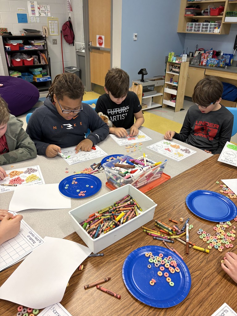 students working on a valentine's activity at their table