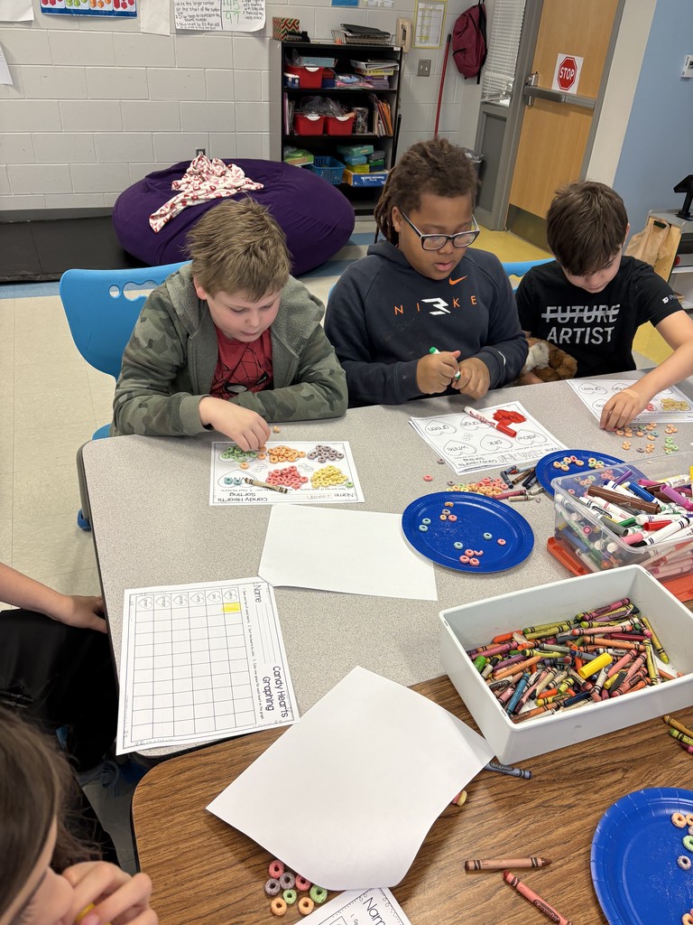 students working on a valentine's activity at their table
