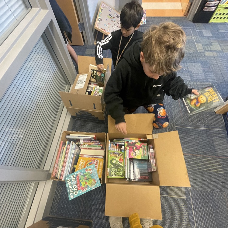 boys looking through boxes of books