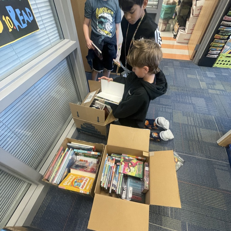 boys looking through boxes of books