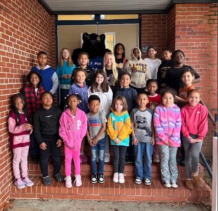 students of the week standing on school steps with the mascot