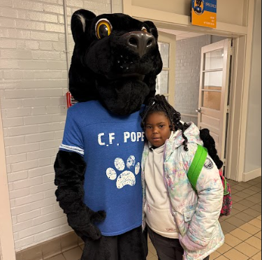 student standing with panther mascot