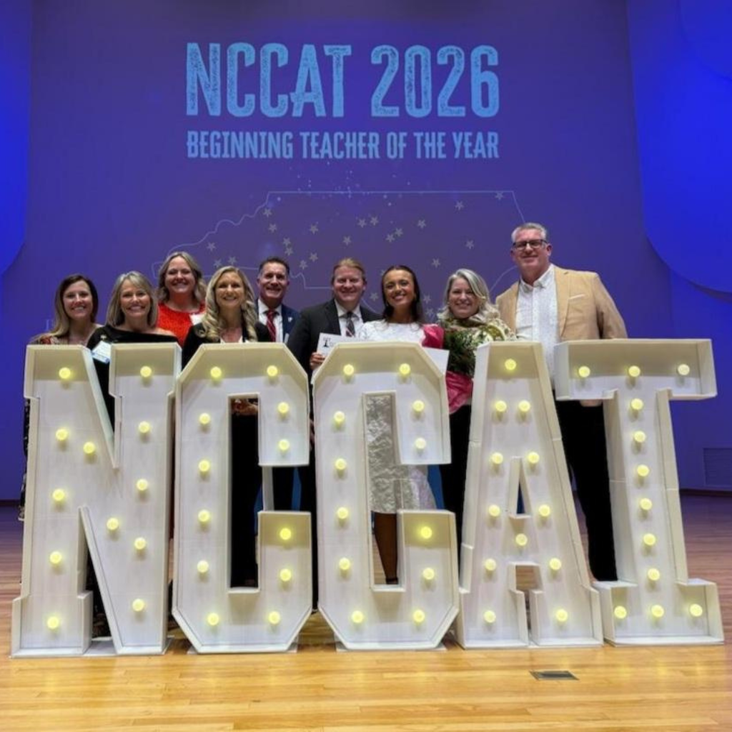 BT receiving award with other educators in front of letters