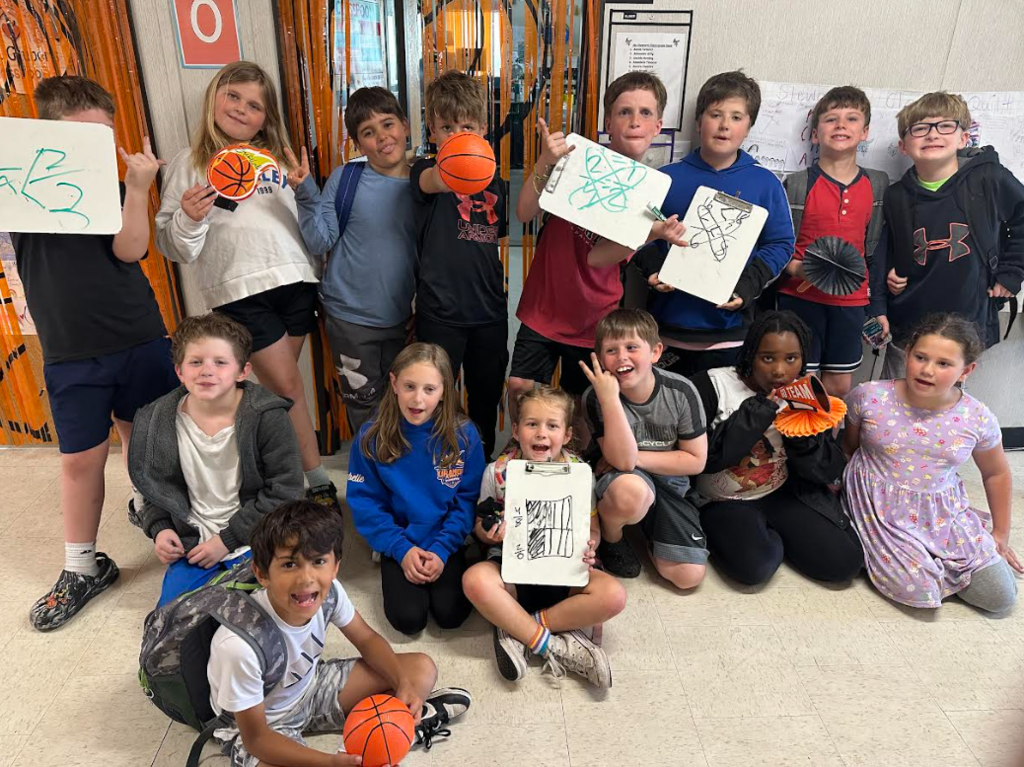 3rd graders holding up their math work