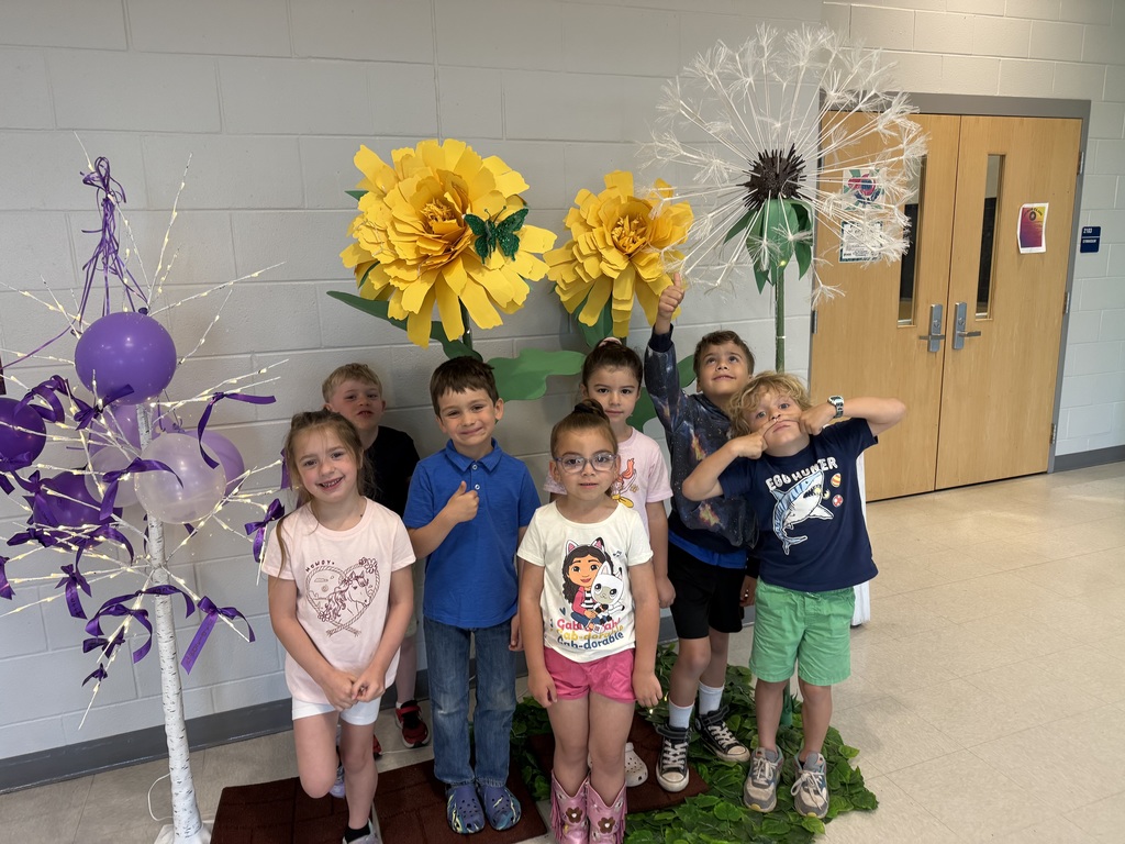military kids writing their names on ribbons and tying them to a tree