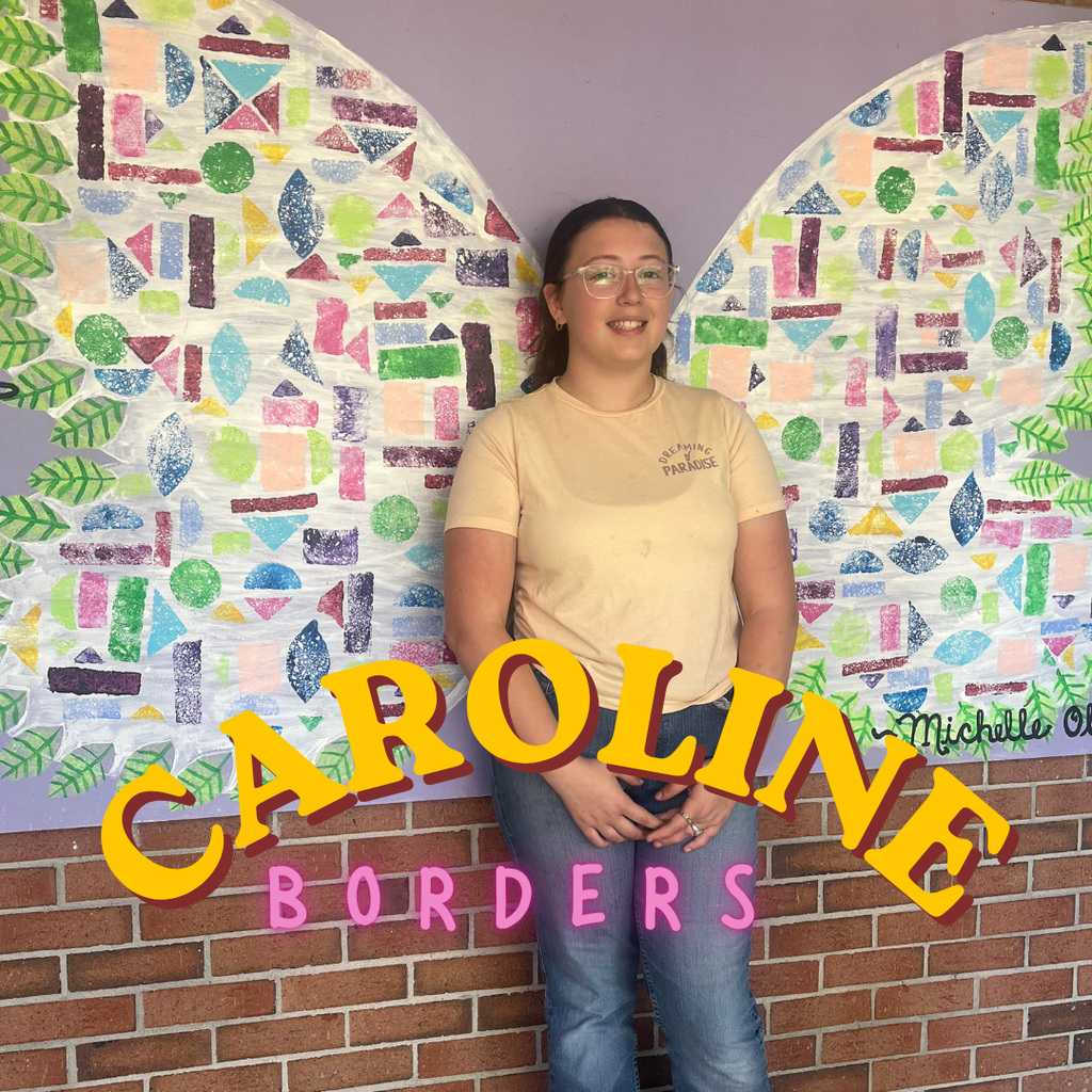 student standing in front of mural
