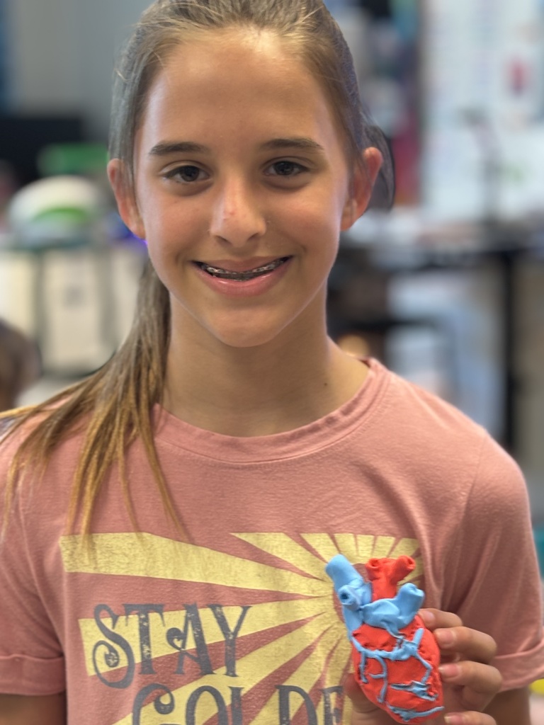 student holding clay heart