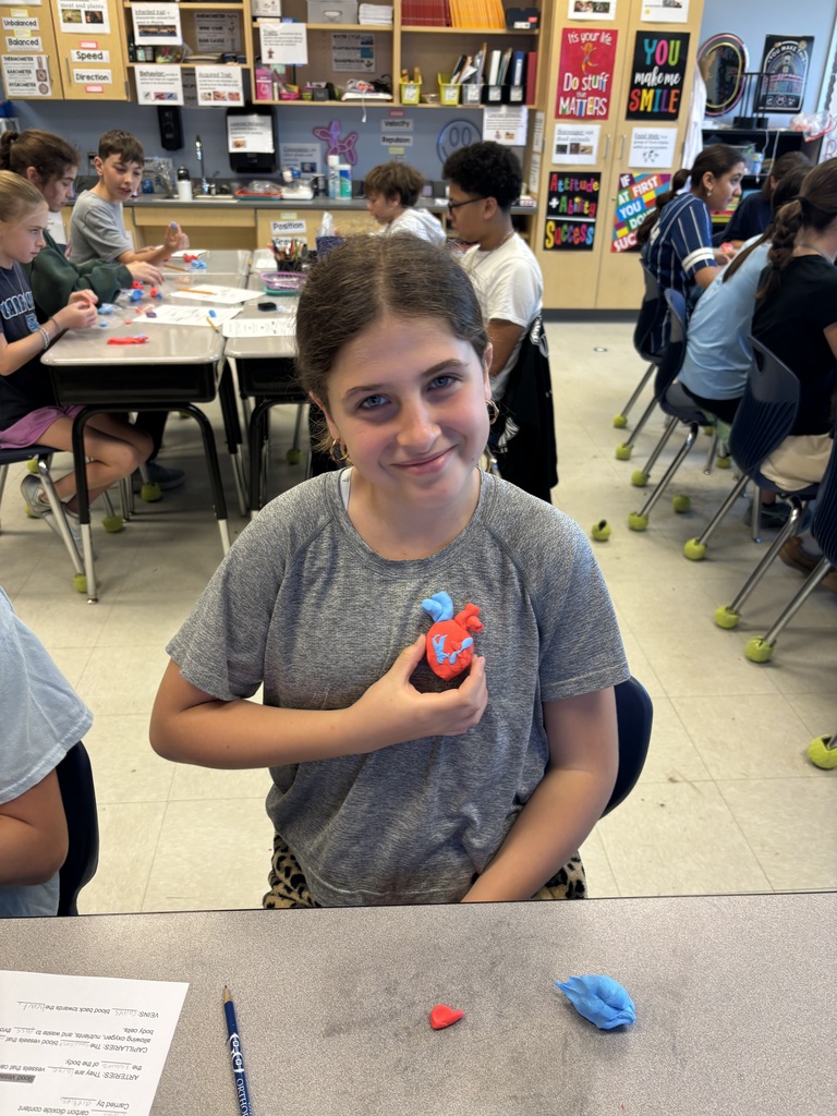 student holding clay heart