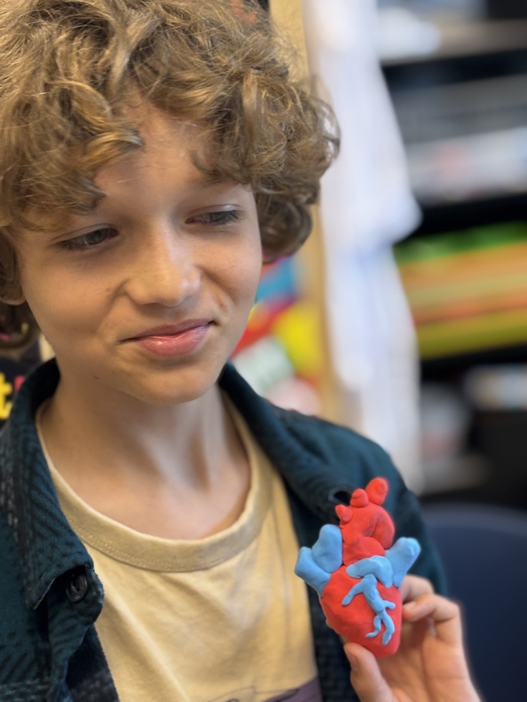 student holding clay heart