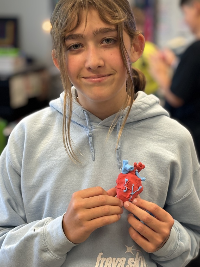 student holding clay heart