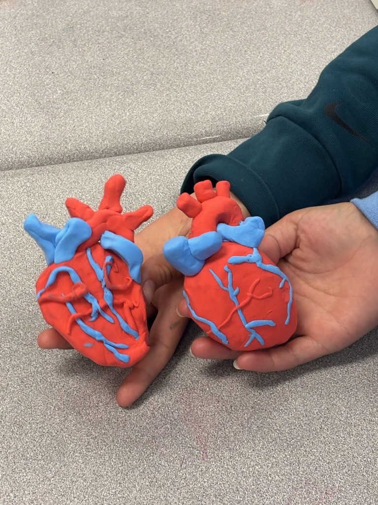 student holding clay heart