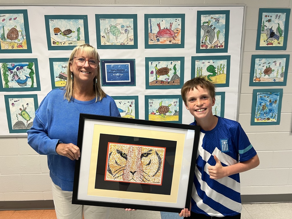 Ms. Hanson & student holding up artwork