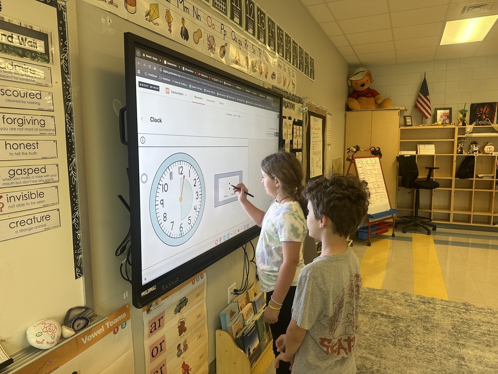first graders writing digital clock times on the newline panel
