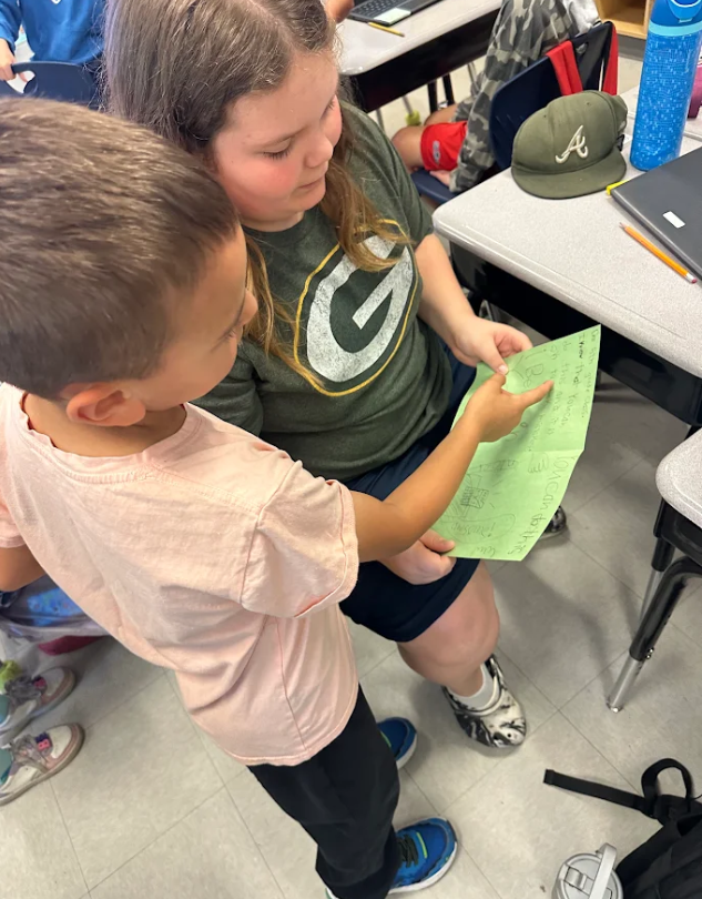 1st graders giving encouragement cards to 5th graders
