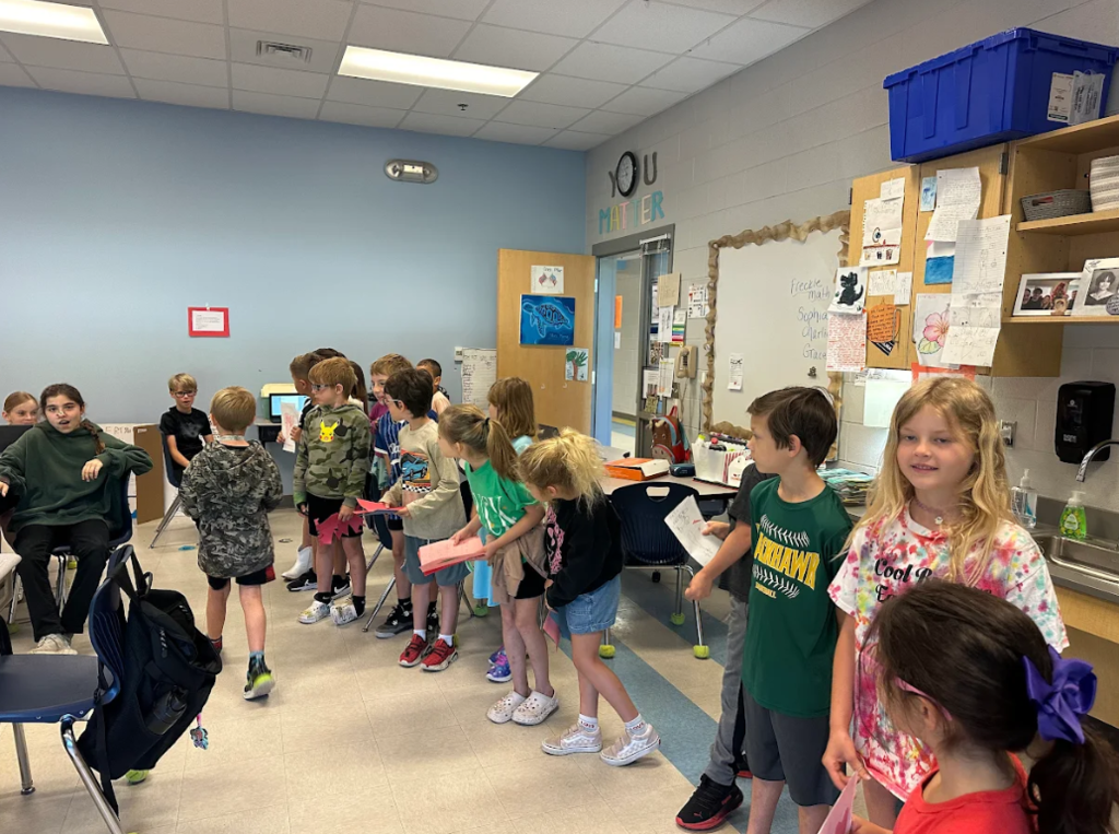 1st graders giving encouragement cards to 5th graders