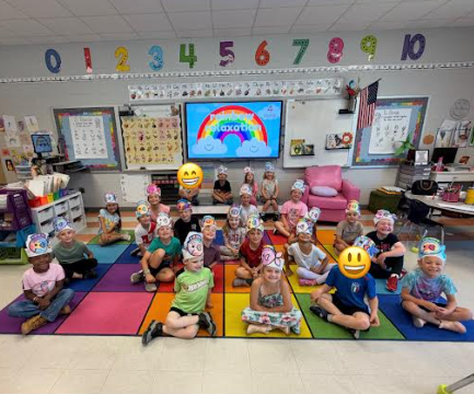 kindergarten kids sitting with preK kids on the rug 