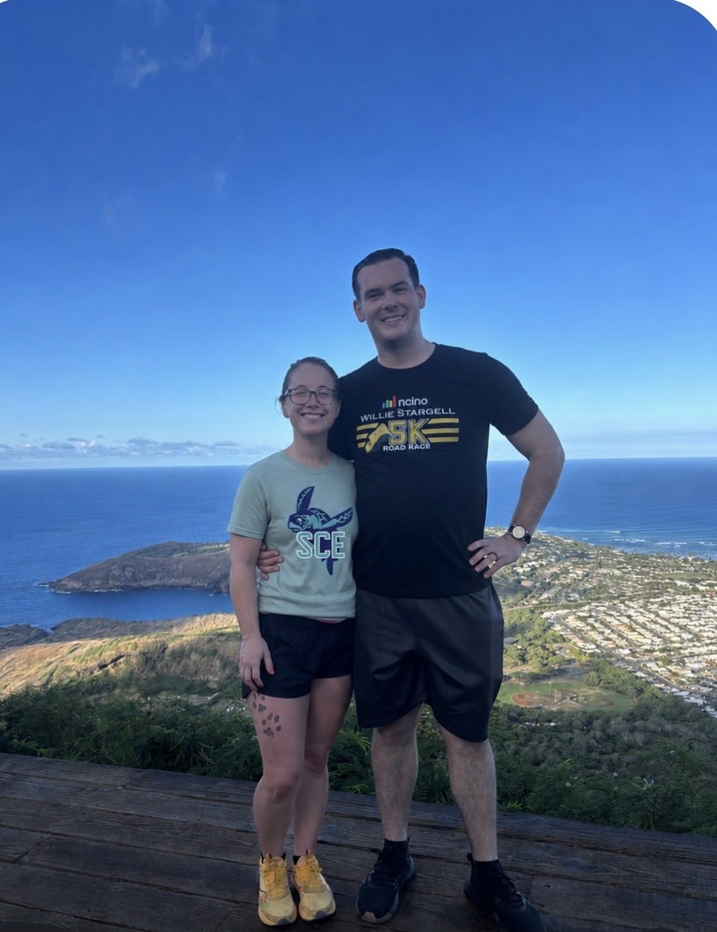 teacher and husband standing over an outlook on a island