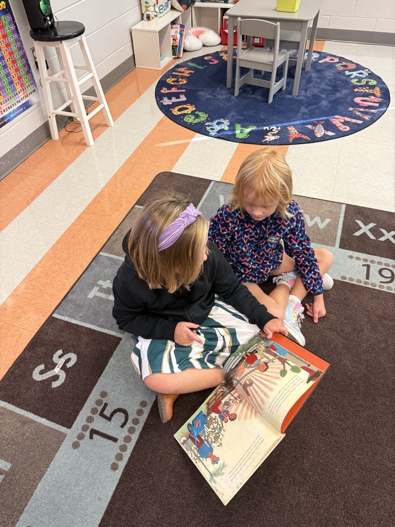 first grade students reading in small groups on the carpet