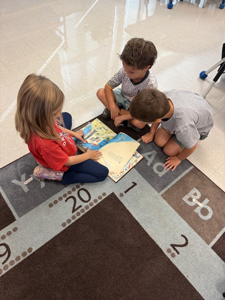 first grade students reading in small groups on the carpet