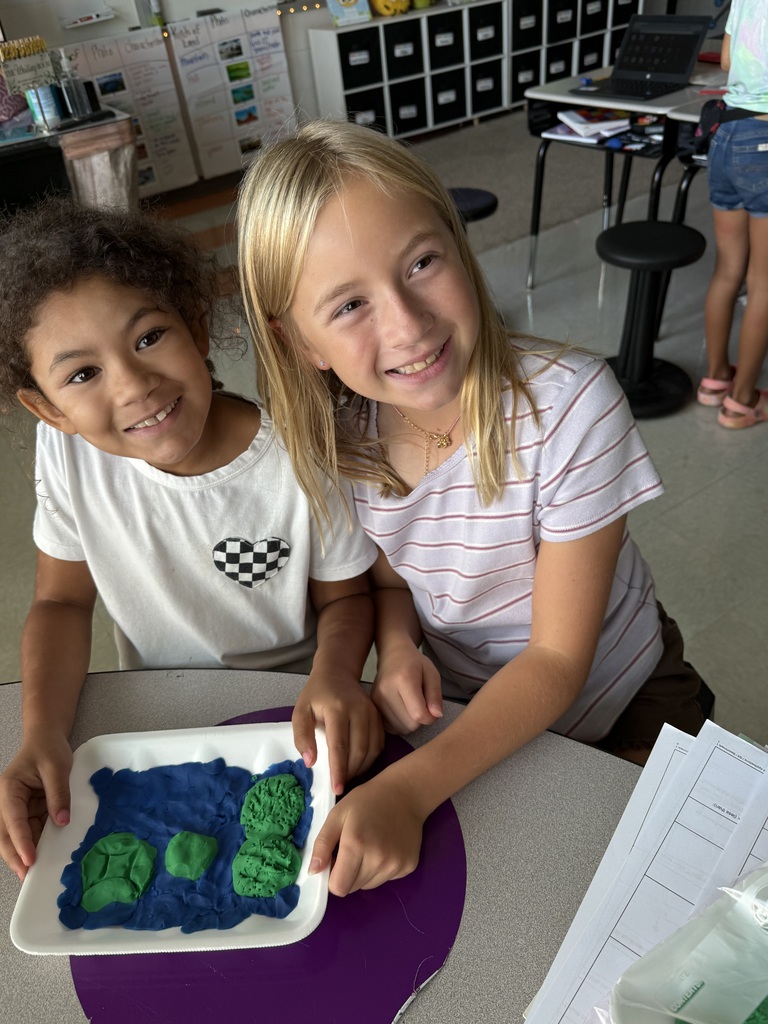 3rd grade students showing off their playdough landform creations