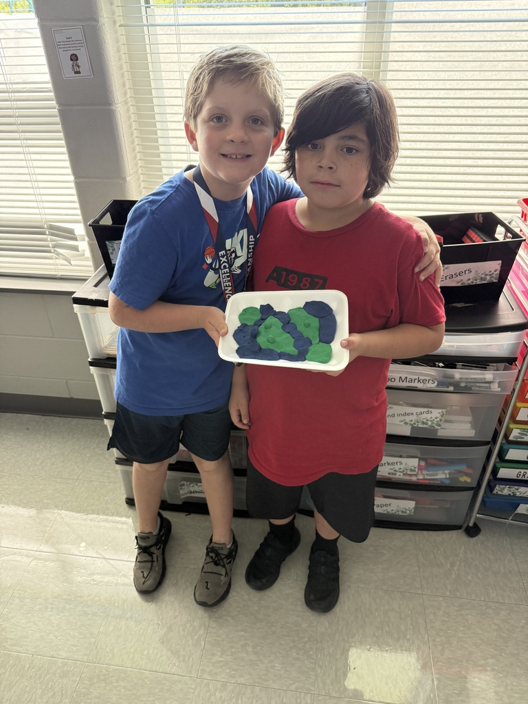 3rd grade students showing off their playdough landform creations