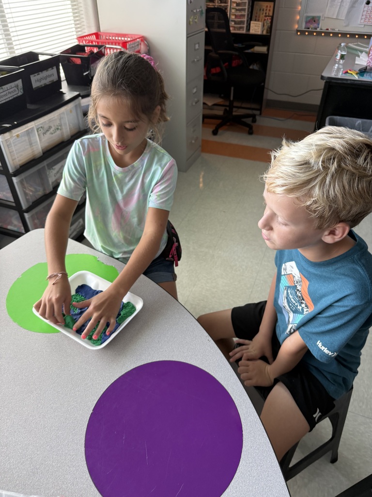 3rd grade students showing off their playdough landform creations
