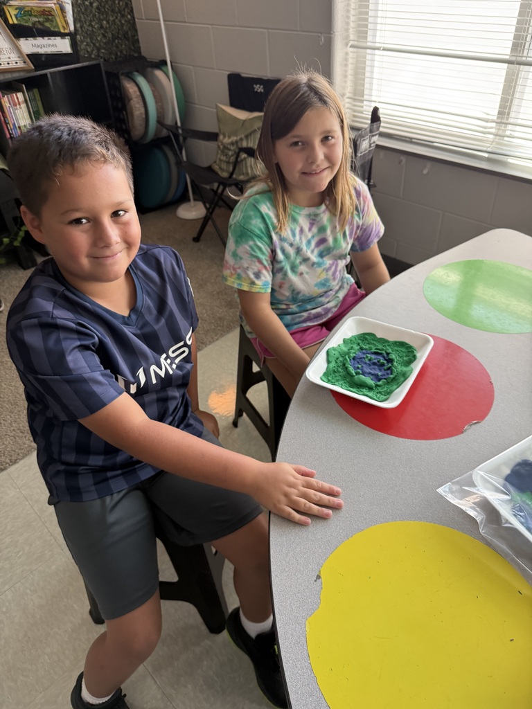 3rd grade students showing off their playdough landform creations