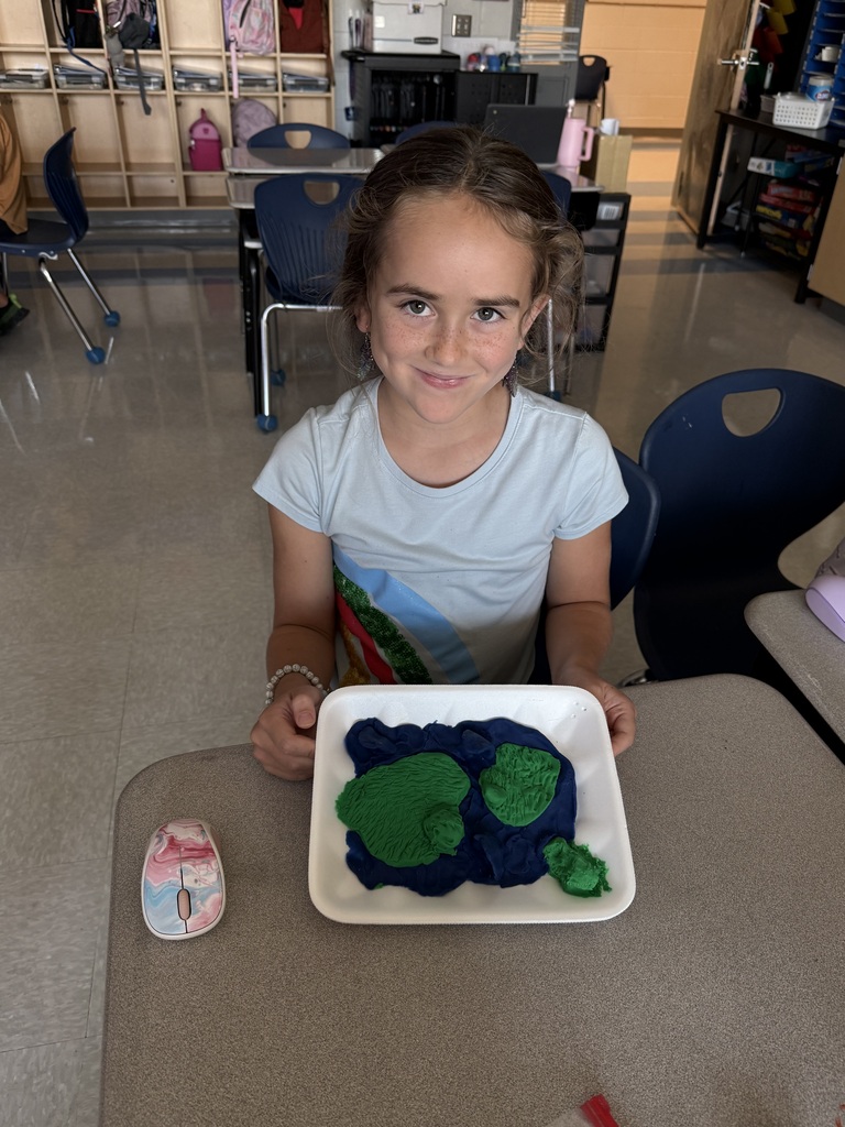3rd grade students showing off their playdough landform creations