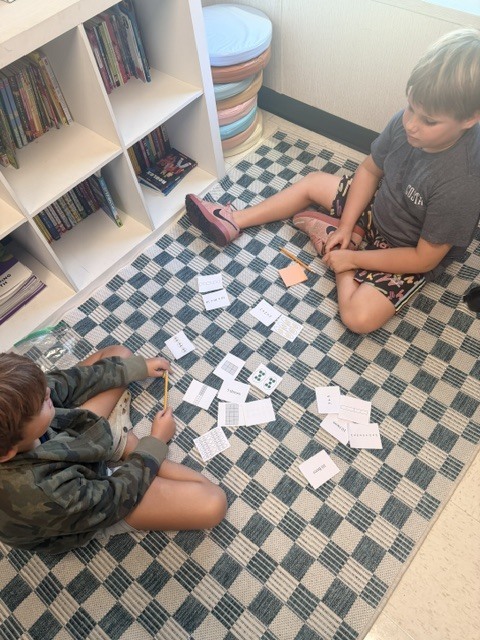 3rd graders working on a multiplication game in small groups