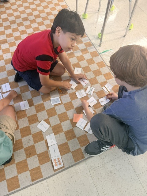 3rd graders working on a multiplication game in small groups