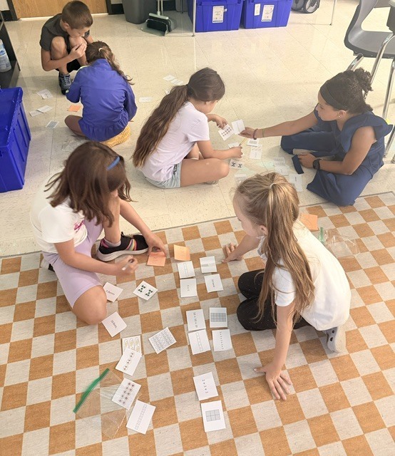 3rd graders working on a multiplication game in small groups