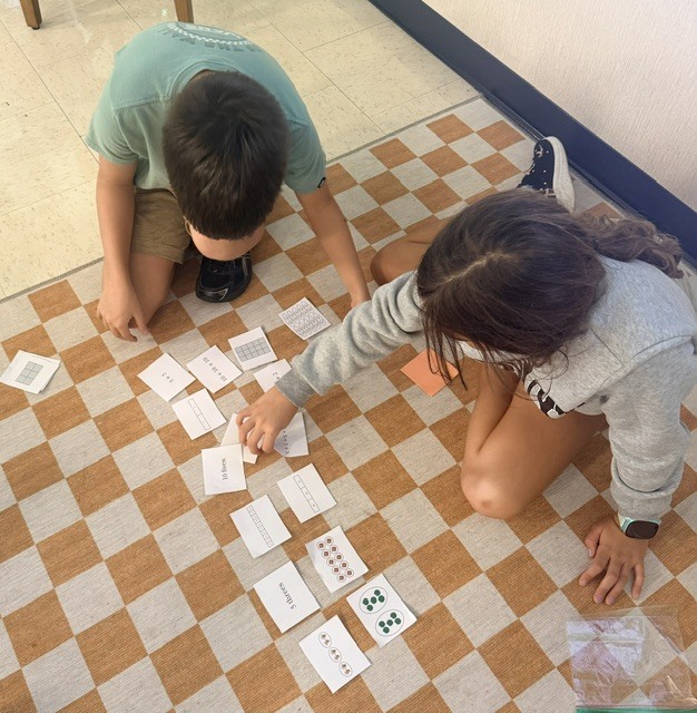 3rd graders working on a multiplication game in small groups