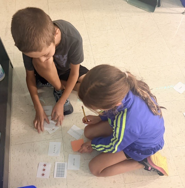3rd graders working on a multiplication game in small groups