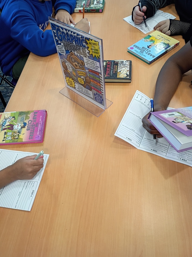 Ms. Harvey's students participating in a book tasting activity in the media center.