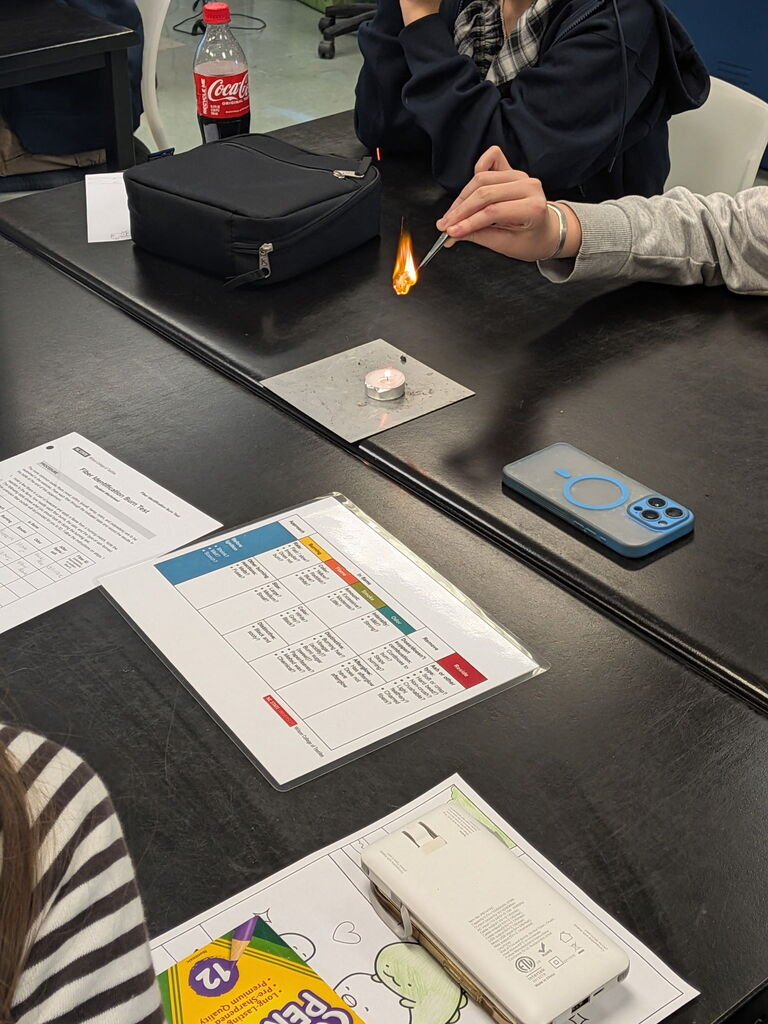 a piece of material burns with cheat sheet visible on table